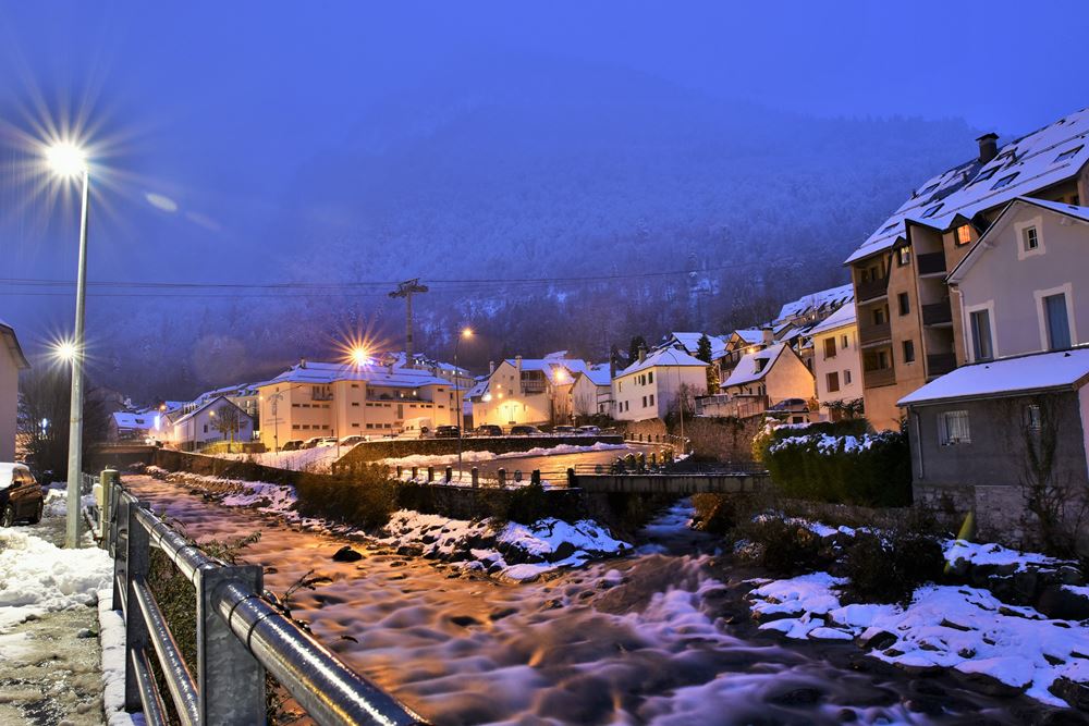 Vue  de Cauterets enneigée et du Gave de Pau à la tombée de la nuit