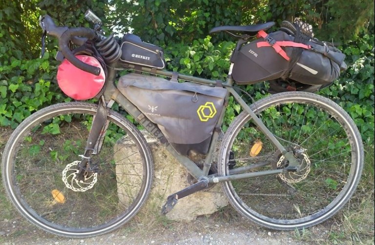 Vélo et sacoches de bikepacking poussiéreux après avoir roulé sur le canal des Deux-Mers