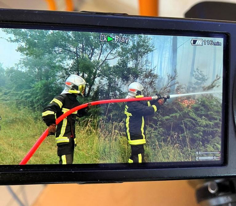 Écran du moniteur de la caméra d'une journaliste montrant les pompiers qui luttent contre l'incendie de la forêt de pins à Saumos en 2022