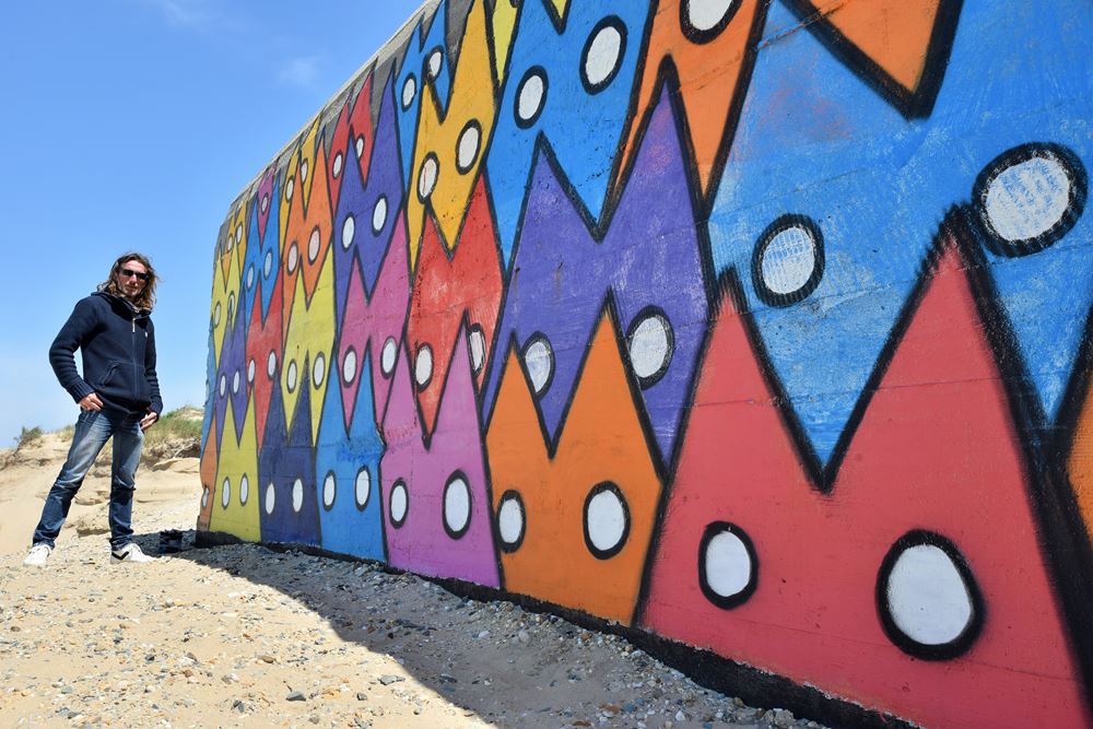 A Soulac-sur-Mer, Yann Müller pose devant son œuvre : M le Chat peint sur un blockhaus