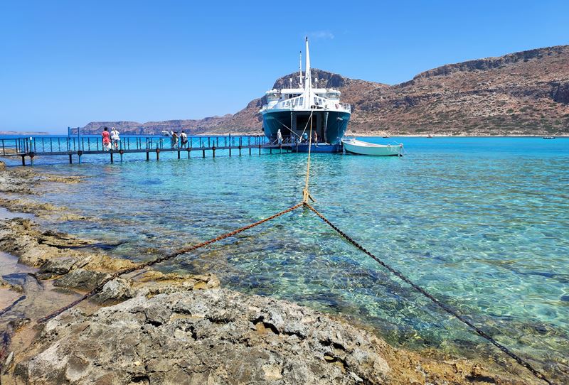 Un ferry amarré au ponton, dans les eaux translucides du lagon de Balos Beach