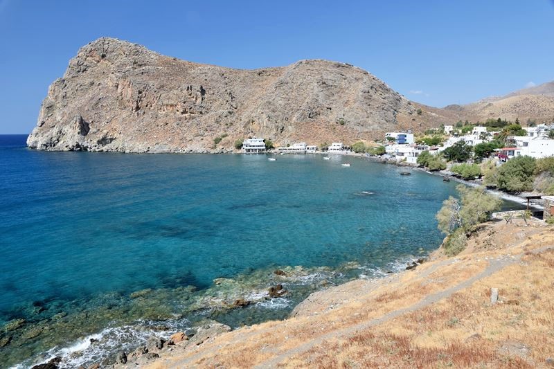 Vue d'ensemble du village de Lendas, qui donne sur les eaux cristallines de la Mer de Lybie et qui est situé aux pieds des montagnes.