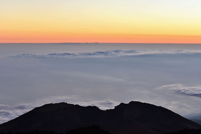 Le soleil vien de se coucher sur la mer de nuages au-dessus de la caldeira du volcan Teide. Au premier, plan le cratère béant d'un volcan