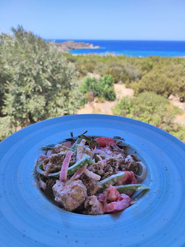 Vue sur le repas et la mer depuis la terrasse du restaurant Glykeria face à la mer, non loin de la plage de Kedrodasos