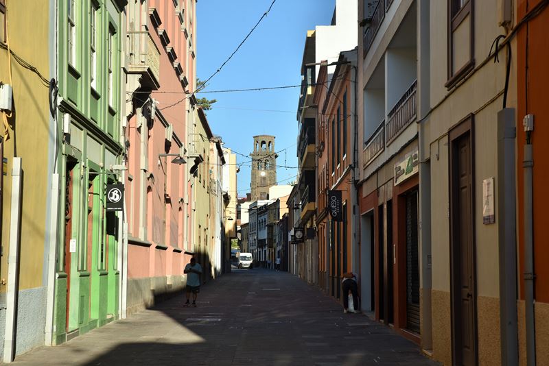 Les façades colorées des maisons dans une ruelle de la ville coloniale de San Cristobal de la Laguna, avec un clocher en arrière-plan