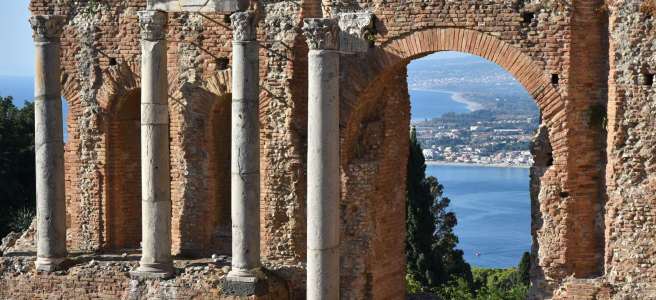 Le mur de scène du théâtre antique de Taormine et ses colonnes devant la mer en arrière-plan